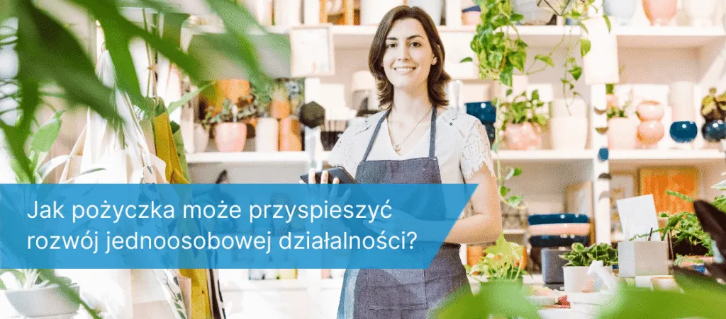 Kobieta w fartuchu stojąca w jasnym, roślinnym sklepie, trzymająca tablet i uśmiechająca się do kamery